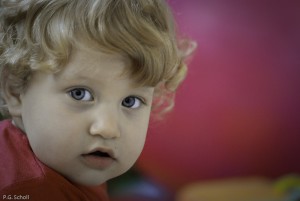 Enfant aux yeux bleus sur fond violet